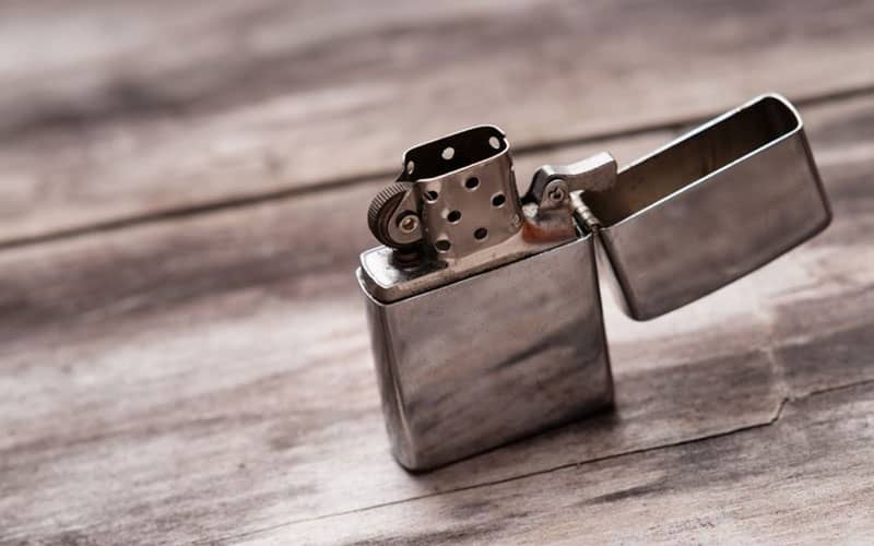 فندک فلزی روی سطح چوبی