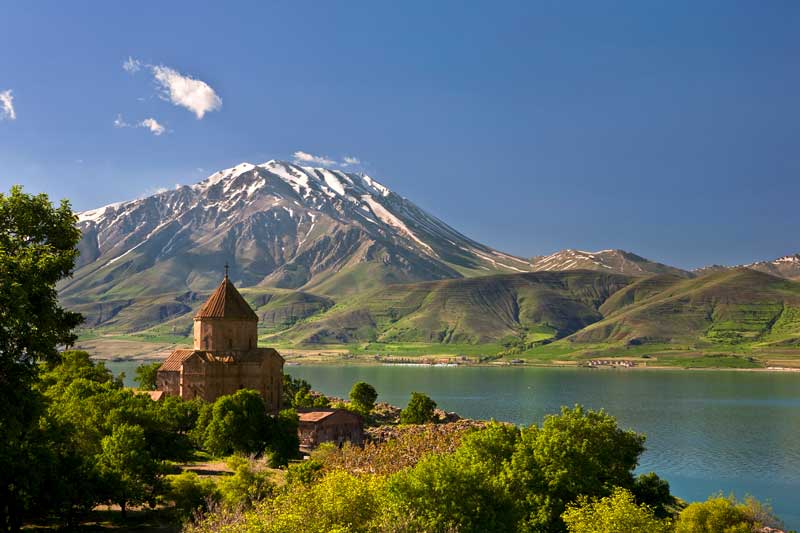 کلیسا با گنبد مخروطی و صلیب مقابل کوه برفی در جزیره آختامار (Akdamar Island)