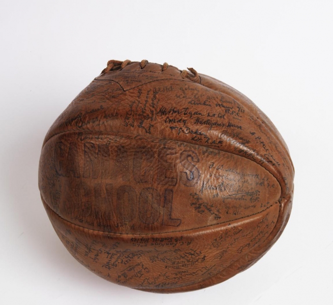 football made from eight shaped panels of brown leather stitched together. The ball bears the following handwritten inscription: 'BRITISH OFFICERS PRISONERS OF WAR CAMP. 1918. HOLZMINDEN. GERMANY. FOOTBALL CLUB SIGNATURE BALL.', which is enclosed by the signatures of Holzminden POWs.