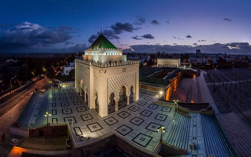 ساختمانی تاریخی با گنبد سبز در حیاطی بزرگ در تاریکی شب