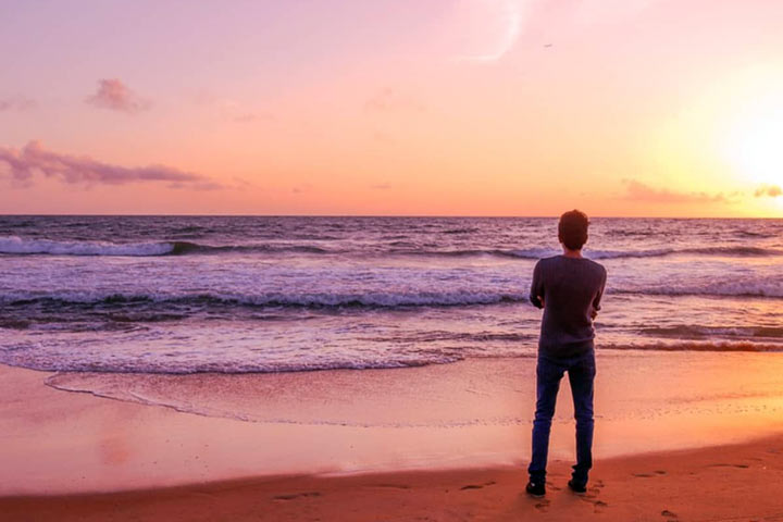 مردی در ساحل دریا در حال لذت بردن در تنهایی