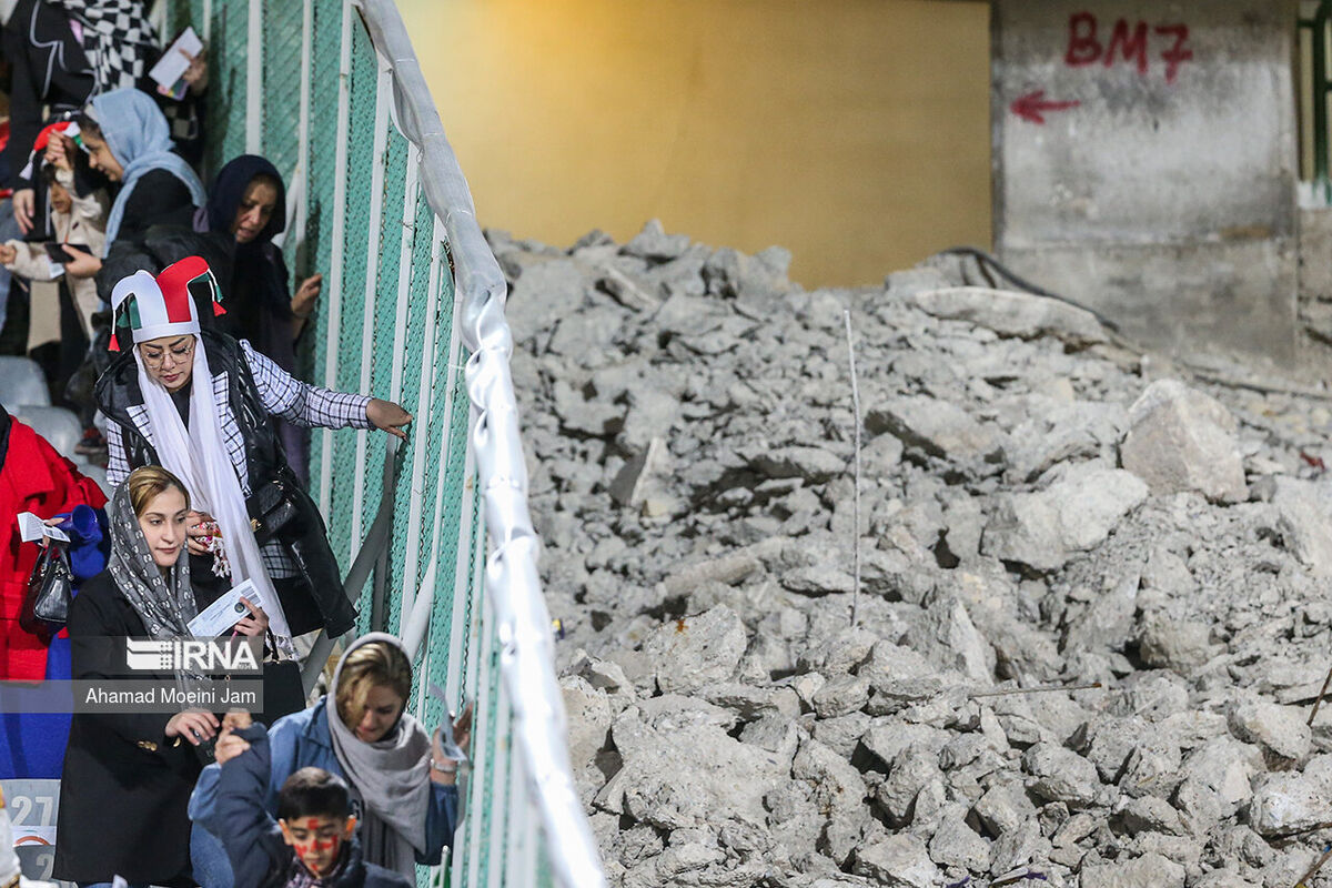 عکس| این‌جا منطقه جنگی نیست، استادیوم آزادی است/ تصویری عجیب از زنان تماشاگر در کنار سکوهای مخروبه ورزشگاه آزادی