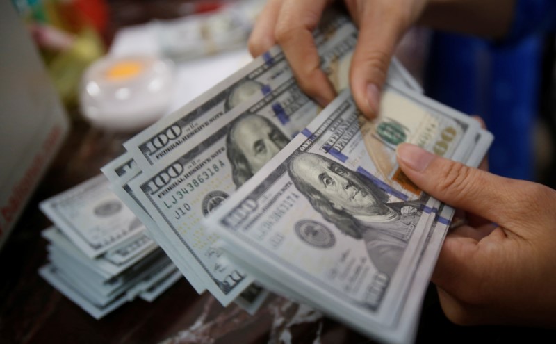 Dollar edges lower, but set for weekly gain after Powell's speech