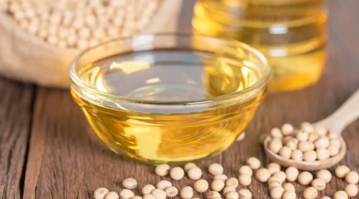 یک کاسه روغن سویا در کنار دانه‌های آن