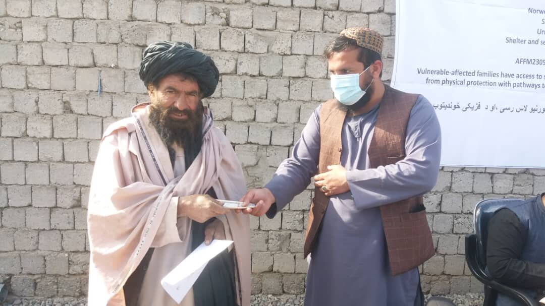 طالبان در حال پخش پول و مواد غذایی بین مهاجران افغان/عکس