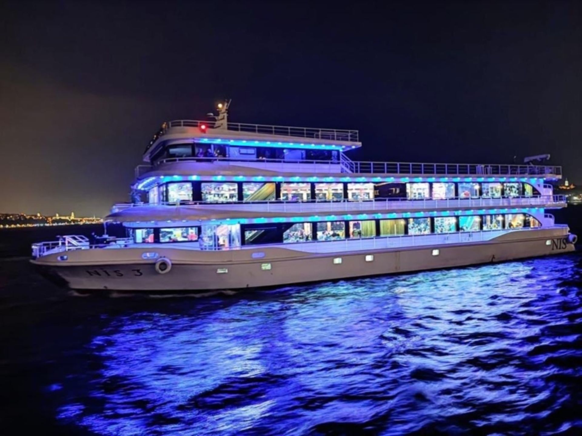 کشتی تفریحی کیش در شب و انعکاس نور در آب