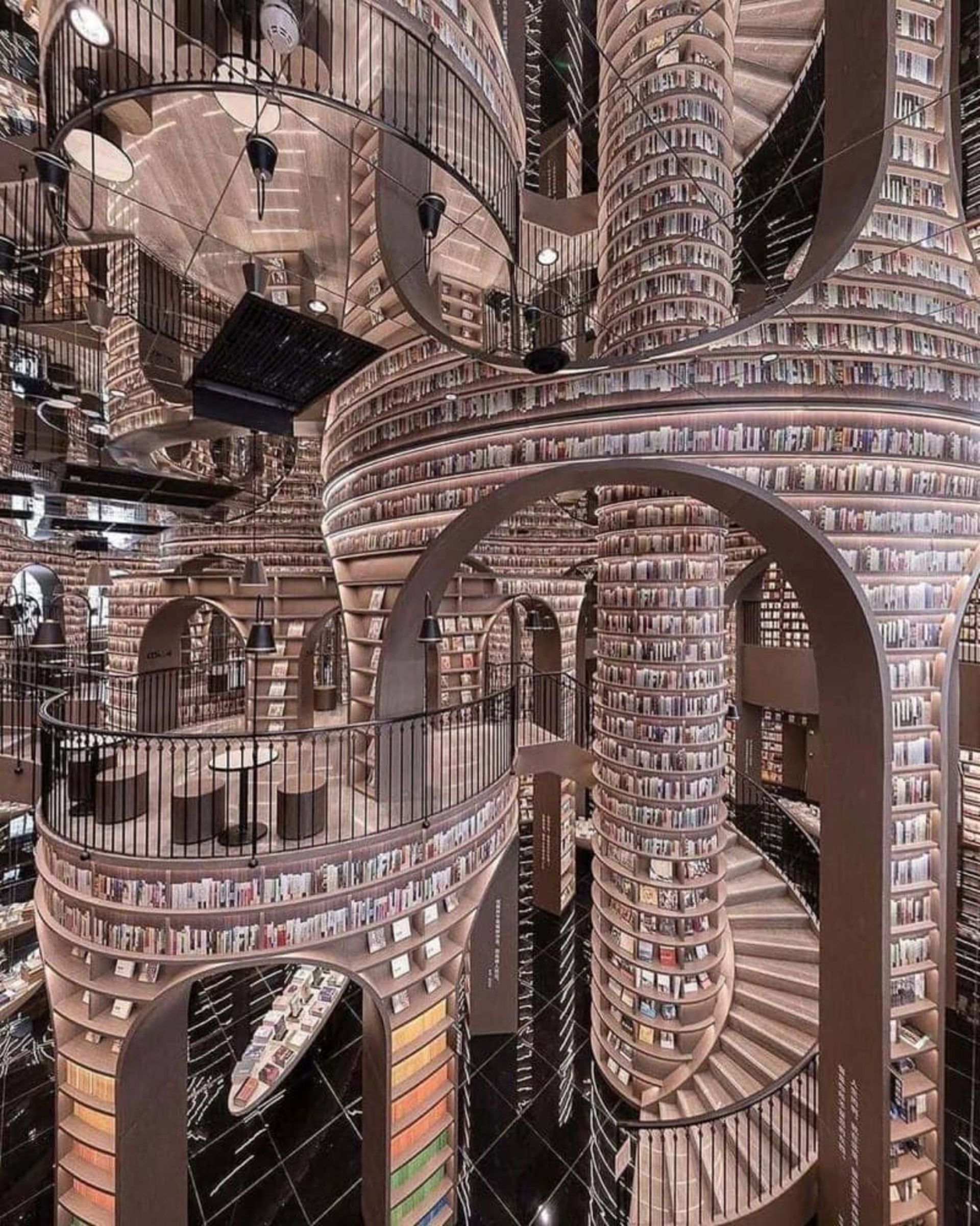 کتابفروشی ژونگ‌شوگ با قفسه‌های بلند کتاب، راه‌پله‌های مارپیچ و طاق‌های قوسی شکل