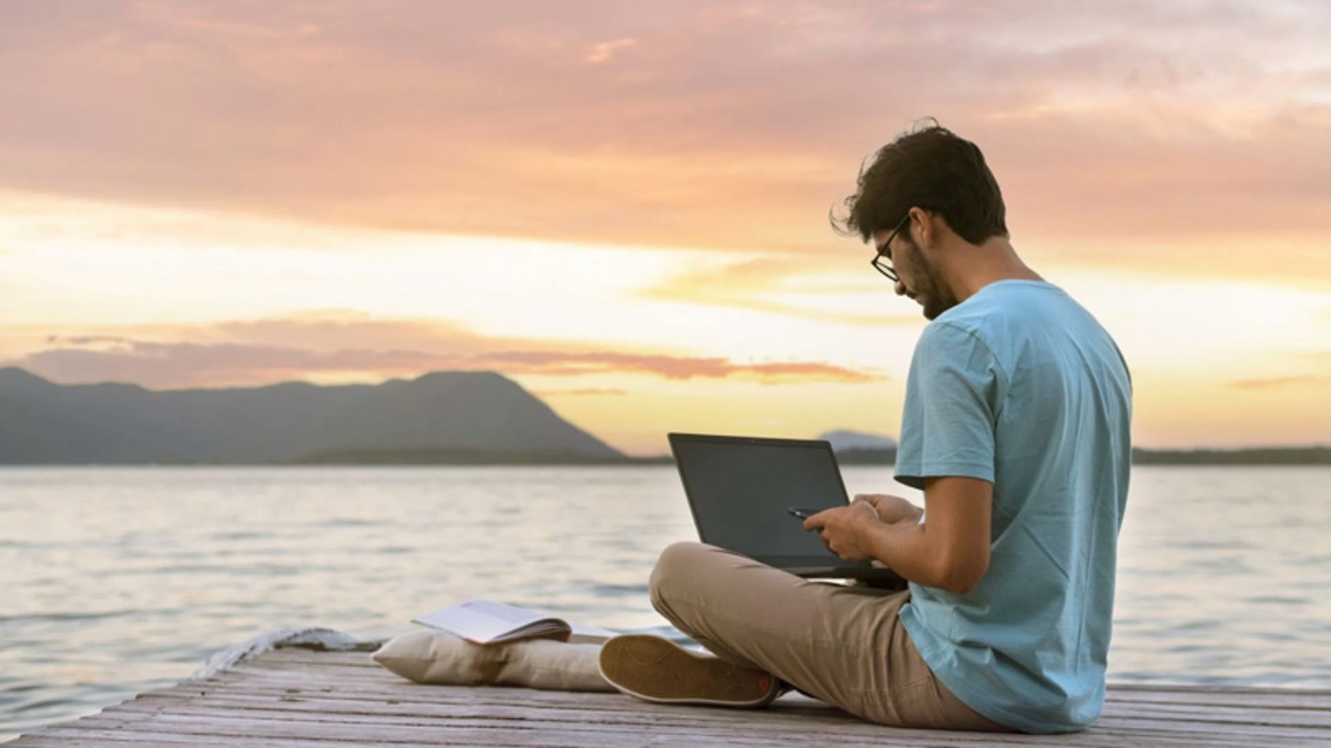 فرد دیجیتال نومد درحال کار در ساحل دریا