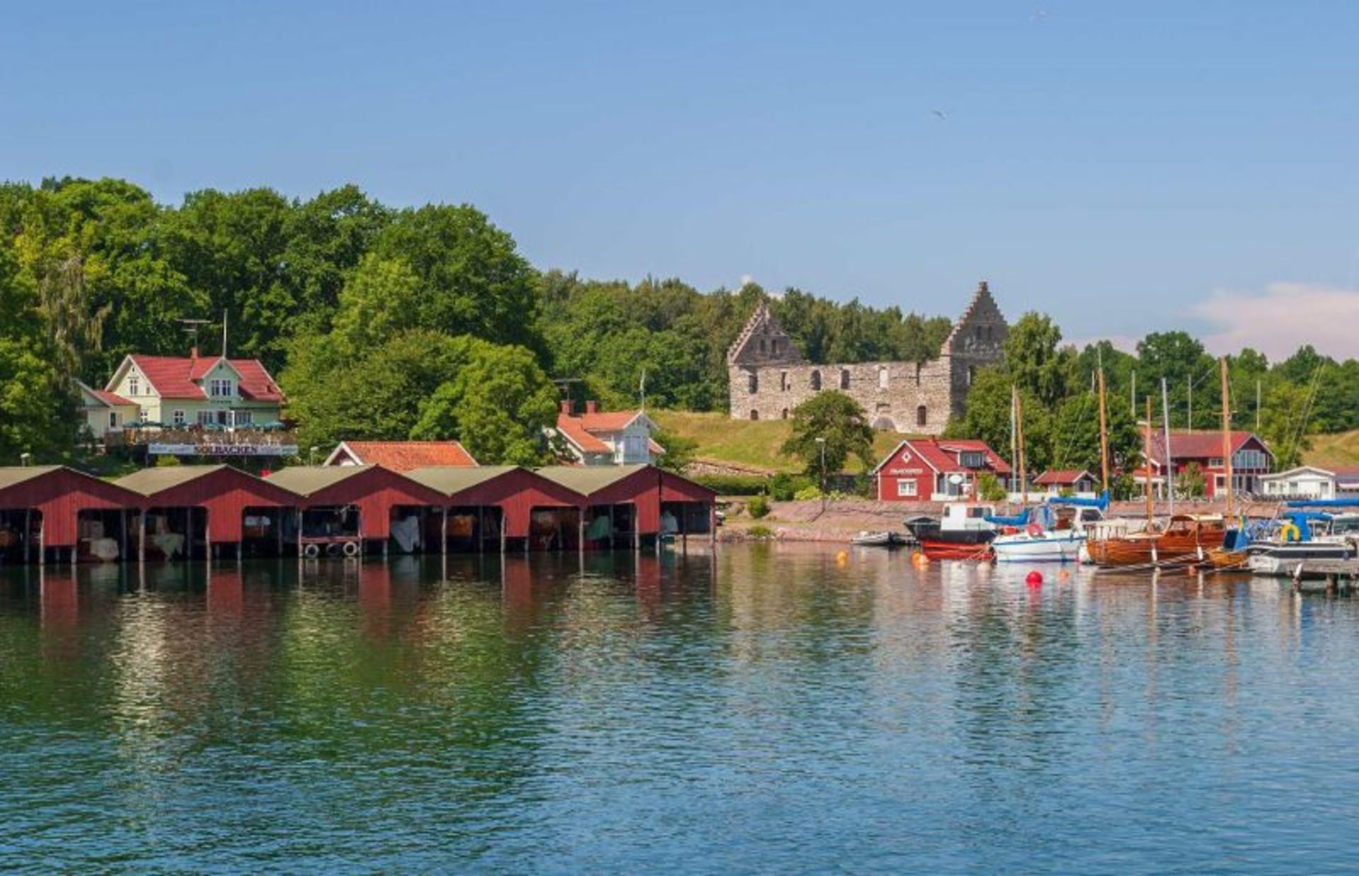 خانه های مسکونی، پوشش گیاهی و قایق ها در دریاچه وترن