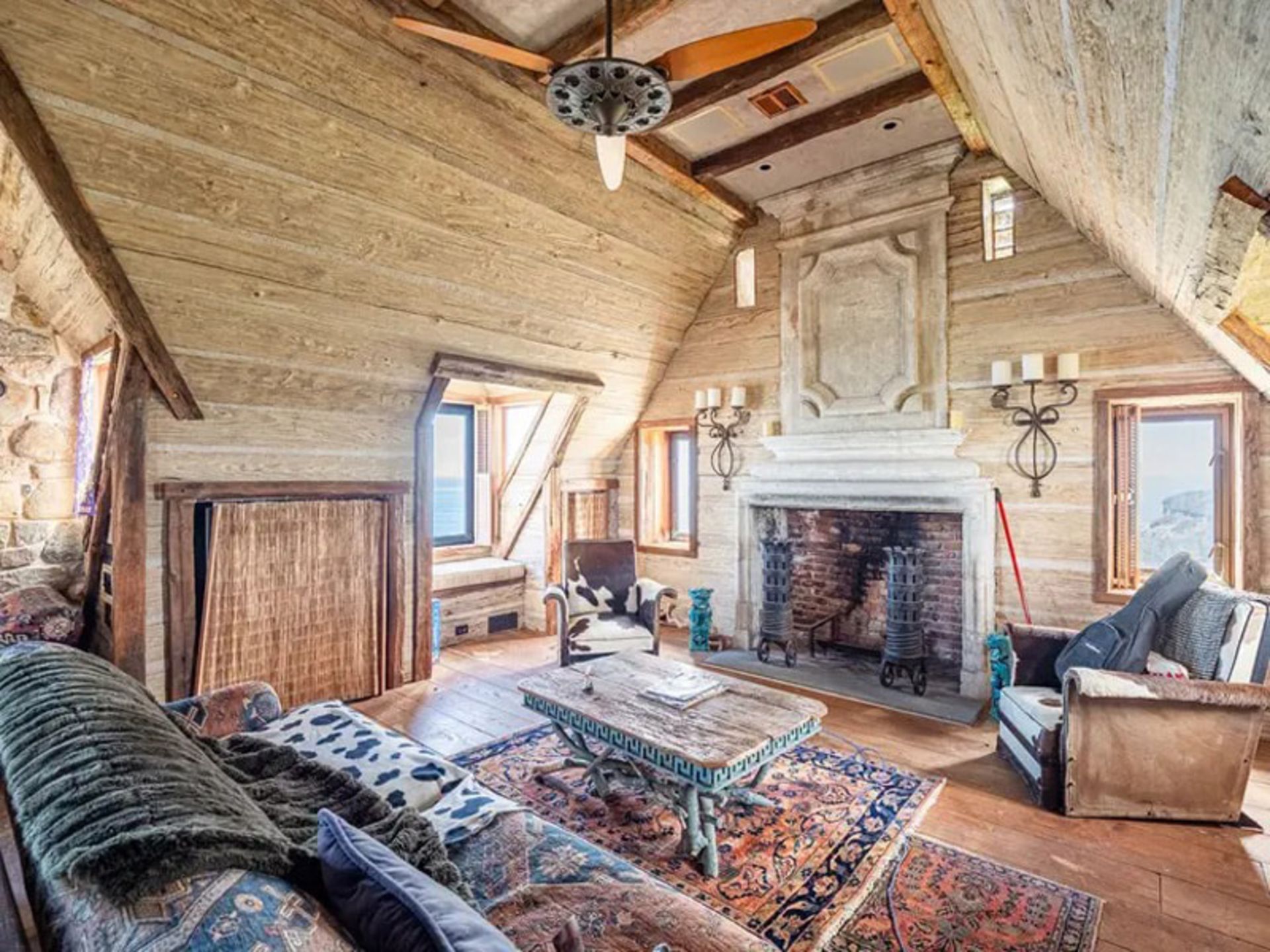 اتاق نشیمن با شومینه هیزمی  در  عمارت سنگی مونتاوک